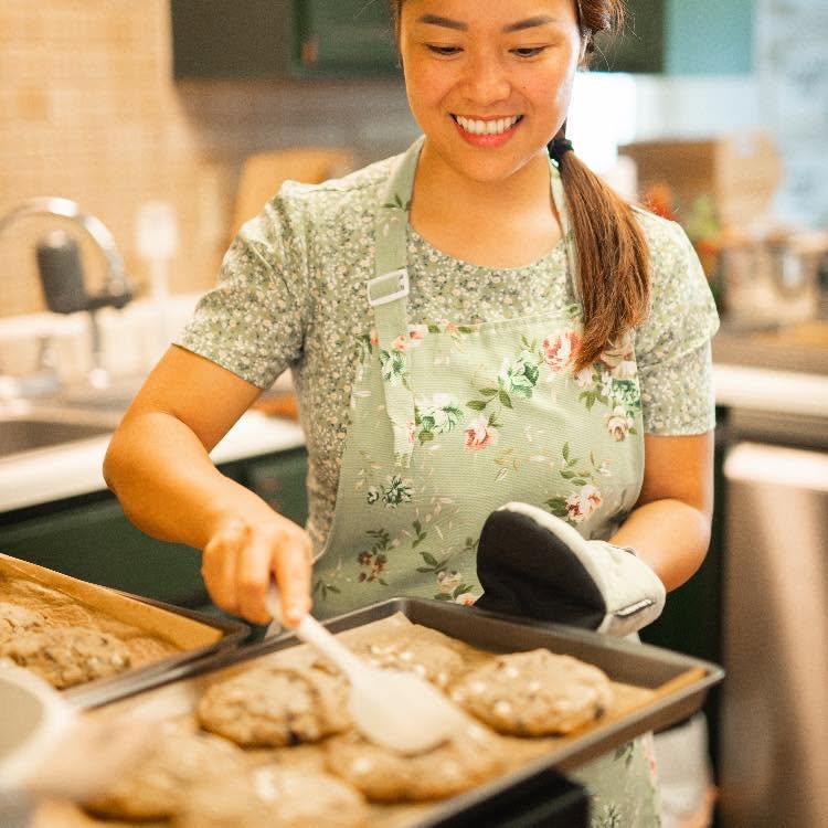 Cookie Paradise baker pulling a fresh tray of cookies from the oven